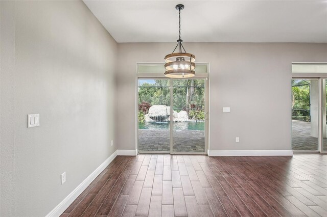 19711 Wellington Manor Blvd, Lutz, FL 33549 - unfurnished dining area with dark wood-type flooring and a chandelier