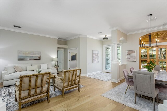 11938 Royce Waterford Cir, Tampa, FL 33626 - dining room featuring ornate columns, a chandelier, light wood-style floors, crown molding, and baseboards