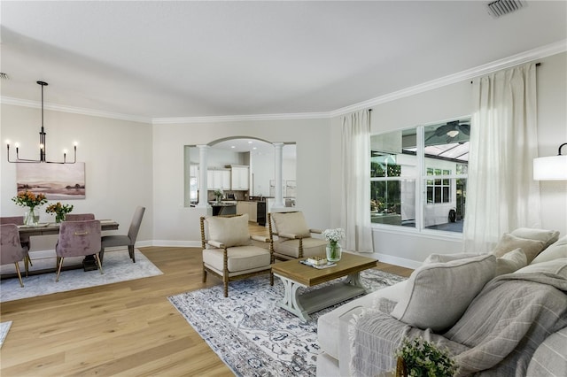 11938 Royce Waterford Cir, Tampa, FL 33626 - living area featuring ornamental molding, arched walkways, light wood-style floors, a chandelier, and baseboards