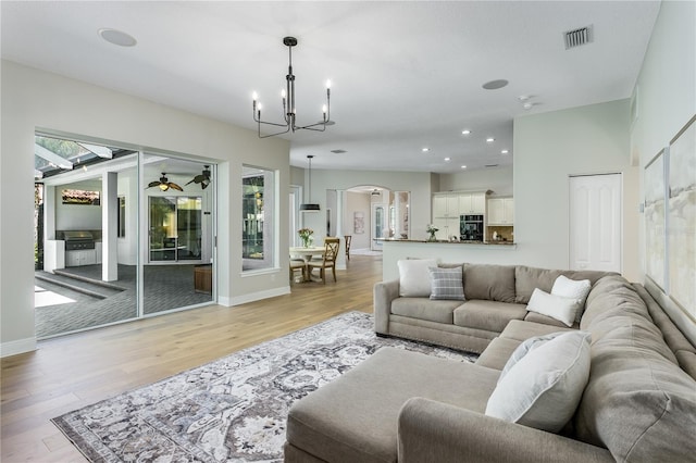 11938 Royce Waterford Cir, Tampa, FL 33626 - living room featuring a chandelier, arched walkways, light wood finished floors, recessed lighting, and baseboards