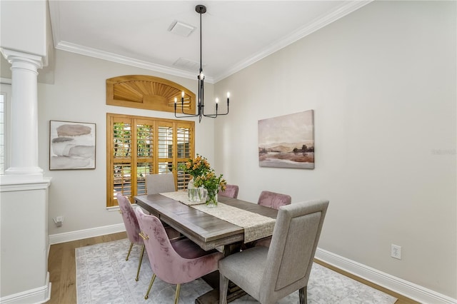11938 Royce Waterford Cir, Tampa, FL 33626 - dining room with ornate columns, crown molding, wood finished floors, baseboards, and a chandelier