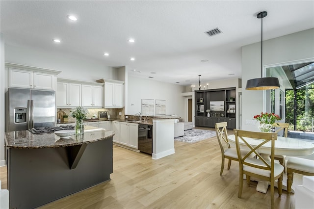 11938 Royce Waterford Cir, Tampa, FL 33626 - kitchen with stainless steel refrigerator with ice dispenser, black dishwasher, a peninsula, a sink, and a chandelier
