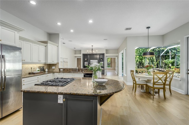 11938 Royce Waterford Cir, Tampa, FL 33626 - kitchen featuring stainless steel fridge, black gas cooktop, baseboards, decorative backsplash, and recessed lighting