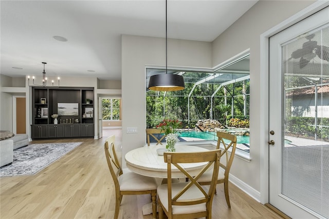 11938 Royce Waterford Cir, Tampa, FL 33626 - dining space with light wood finished floors, a chandelier, and baseboards