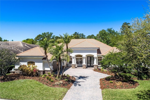 11938 Royce Waterford Cir, Tampa, FL 33626 - view of front of property with decorative driveway, a tiled roof, french doors, and stucco siding