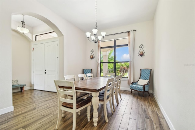 4608 Scott Rd, Lutz, FL 33558 - dining area with arched walkways, wood finished floors, a chandelier, and baseboards