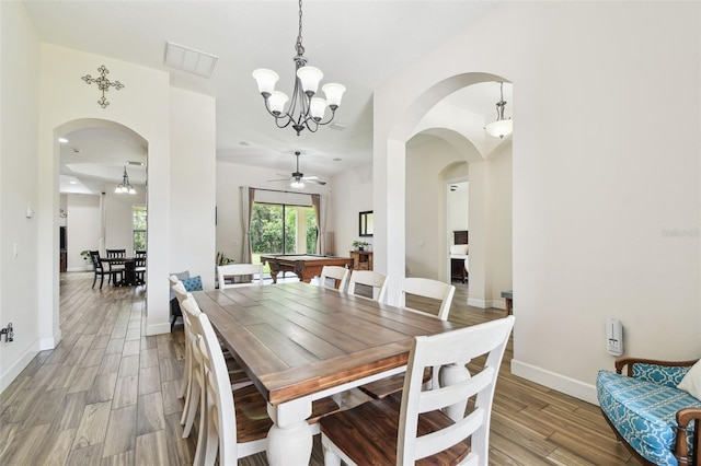 4608 Scott Rd, Lutz, FL 33558 - dining room featuring light wood finished floors, a chandelier, arched walkways, baseboards, and a ceiling fan