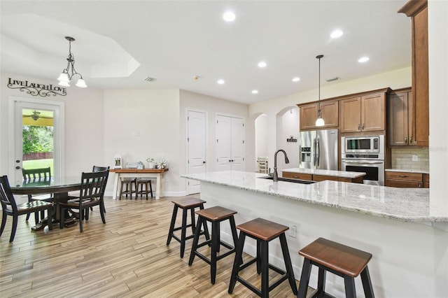 4608 Scott Rd, Lutz, FL 33558 - kitchen with appliances with stainless steel finishes, a sink, arched walkways, recessed lighting, and a breakfast bar