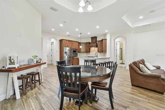4608 Scott Rd, Lutz, FL 33558 - dining room featuring arched walkways, light wood finished floors, recessed lighting, a chandelier, and baseboards