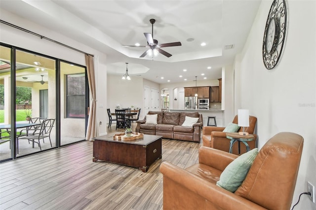 4608 Scott Rd, Lutz, FL 33558 - living area featuring a ceiling fan, light wood-type flooring, a tray ceiling, and recessed lighting
