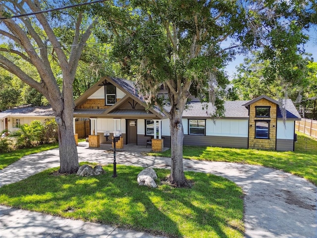 816 9th Ave SW, Largo, FL 33770 - view of front facade with curved driveway, covered porch, and board and batten siding