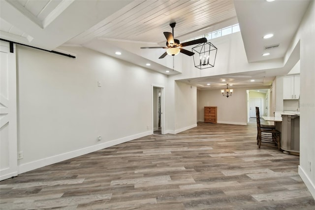 816 9th Ave SW, Largo, FL 33770 - unfurnished living room featuring a chandelier, recessed lighting, a barn door, wooden ceiling, and baseboards