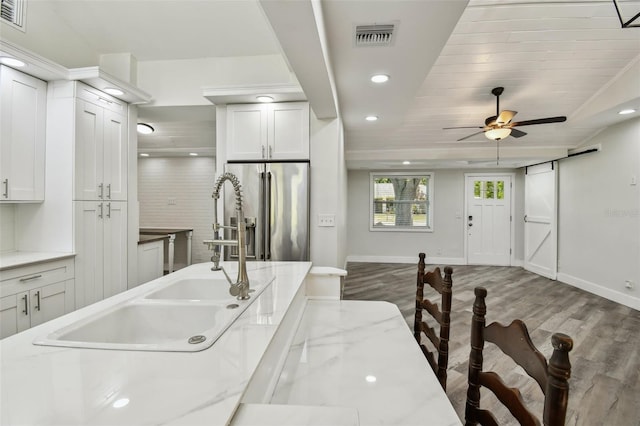 816 9th Ave SW, Largo, FL 33770 - kitchen featuring stainless steel fridge with ice dispenser, wood finished floors, a sink, baseboards, and recessed lighting