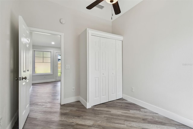 816 9th Ave SW, Largo, FL 33770 - unfurnished bedroom with wood finished floors, a closet, baseboards, a ceiling fan, and lofted ceiling