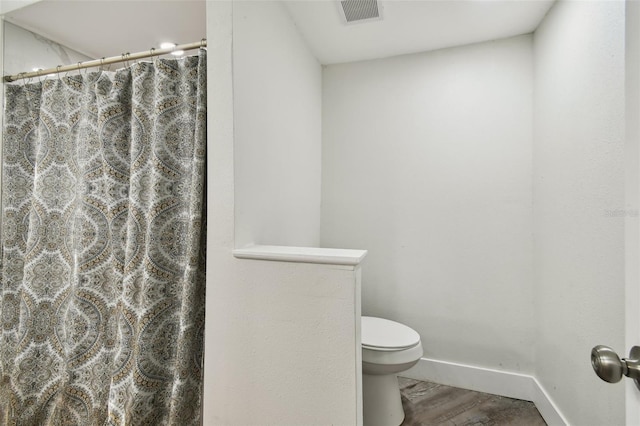 816 9th Ave SW, Largo, FL 33770 - full bath with toilet, baseboards, a shower with shower curtain, and wood finished floors