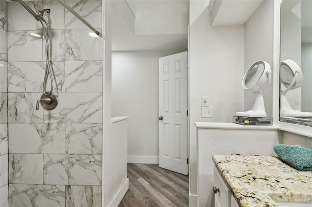 816 9th Ave SW, Largo, FL 33770 - bathroom with wood finished floors, vanity, tiled shower, and baseboards