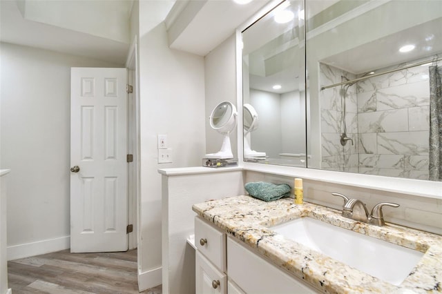 816 9th Ave SW, Largo, FL 33770 - full bathroom featuring vanity, wood finished floors, baseboards, and tiled shower