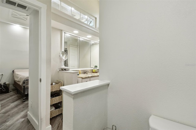 816 9th Ave SW, Largo, FL 33770 - ensuite bathroom featuring wood finished floors, vanity, and toilet