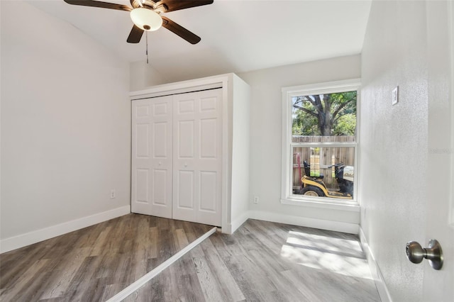 816 9th Ave SW, Largo, FL 33770 - unfurnished bedroom featuring baseboards, wood finished floors, vaulted ceiling, a closet, and a ceiling fan