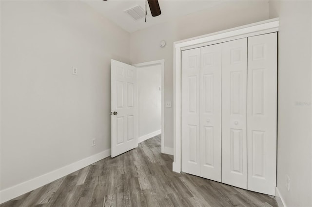 816 9th Ave SW, Largo, FL 33770 - unfurnished bedroom with wood finished floors, a closet, baseboards, and a ceiling fan