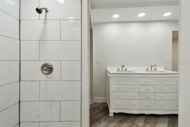816 9th Ave SW, Largo, FL 33770 - bathroom featuring wood finished floors, a tile shower, and double vanity