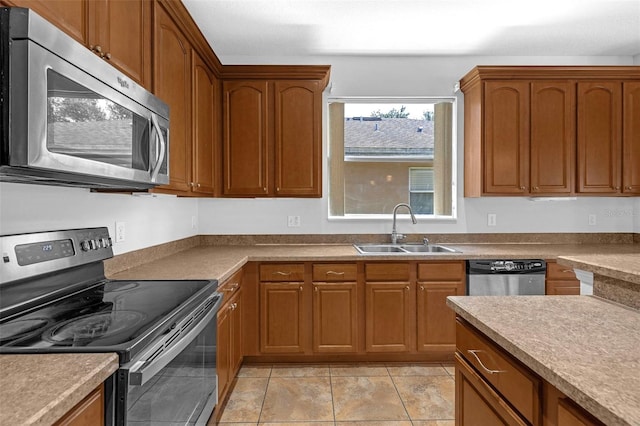1769 Strathmore Cir, Mount Dora, FL 32757 - kitchen featuring appliances with stainless steel finishes, a sink, brown cabinets, and light tile patterned floors