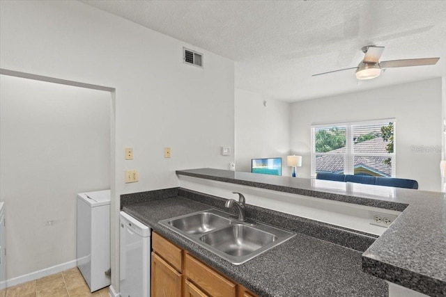 10764 70th Ave Unit 3206, Seminole, FL 33772 - kitchen with a sink, white dishwasher, dark countertops, washer / dryer, and brown cabinets