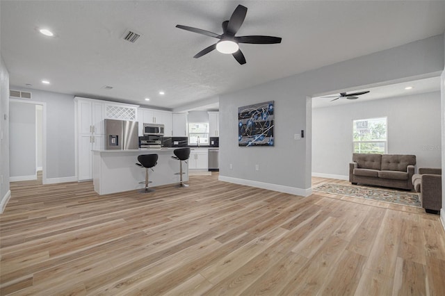 2436 Beacon Groves Blvd, Palm Harbor, FL 34683 - kitchen with stainless steel appliances, open floor plan, ceiling fan, a kitchen breakfast bar, and recessed lighting