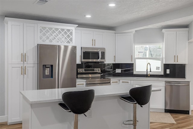 2436 Beacon Groves Blvd, Palm Harbor, FL 34683 - kitchen featuring appliances with stainless steel finishes, a sink, white cabinetry, recessed lighting, and backsplash