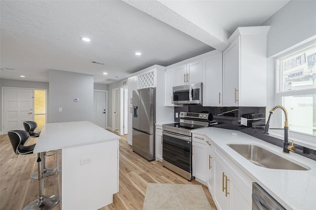 2436 Beacon Groves Blvd, Palm Harbor, FL 34683 - kitchen with stainless steel appliances, a sink, a breakfast bar, recessed lighting, and a center island