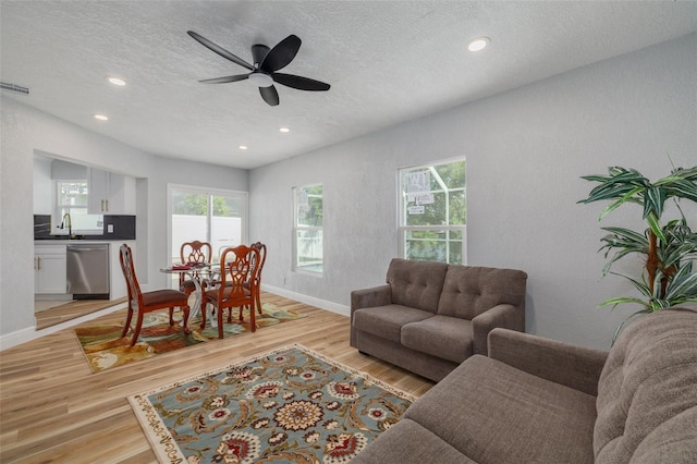 2436 Beacon Groves Blvd, Palm Harbor, FL 34683 - living room featuring a textured ceiling, light wood finished floors, recessed lighting, baseboards, and ceiling fan