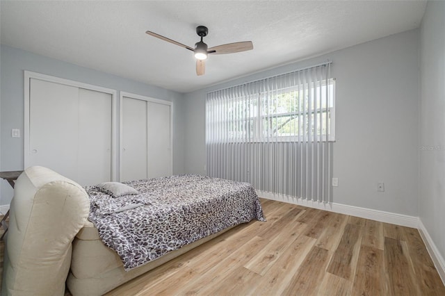 2436 Beacon Groves Blvd, Palm Harbor, FL 34683 - bedroom with multiple closets, light wood-type flooring, baseboards, and ceiling fan