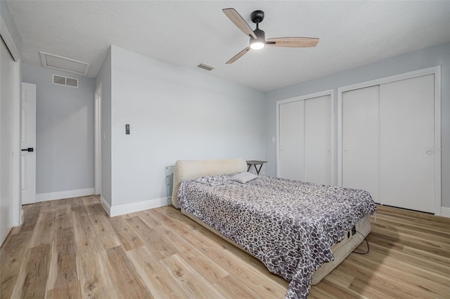 2436 Beacon Groves Blvd, Palm Harbor, FL 34683 - bedroom with multiple closets, light wood-style floors, baseboards, and attic access