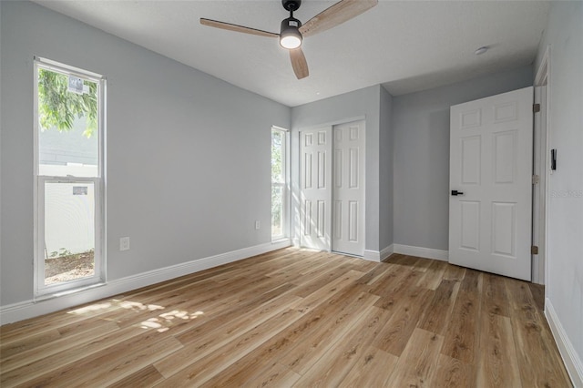 2436 Beacon Groves Blvd, Palm Harbor, FL 34683 - unfurnished bedroom with light wood-style floors, baseboards, a closet, and a ceiling fan