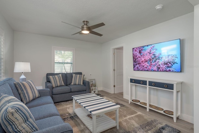 2271 Carolyn Dr, Dunedin, FL 34698 - living room featuring a ceiling fan, wood finished floors, baseboards, and a textured ceiling