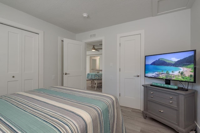 2271 Carolyn Dr, Dunedin, FL 34698 - bedroom with light wood-style floors, a closet, and a textured ceiling