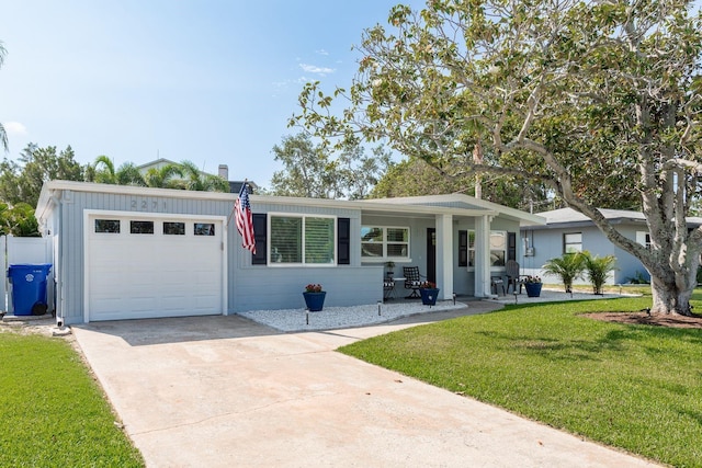 2271 Carolyn Dr, Dunedin, FL 34698 - view of front of home featuring an attached garage, a front lawn, and concrete driveway