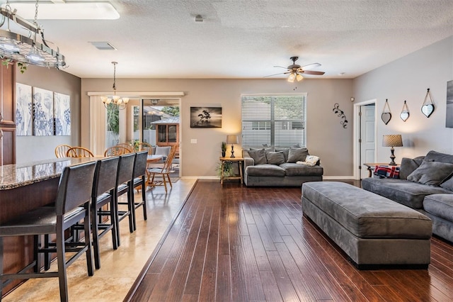 1524 Rhodeswell Ln, Dover, FL 33527 - living room featuring wood-type flooring, a chandelier, ceiling fan, baseboards, and a textured ceiling