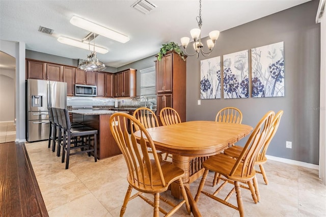 1524 Rhodeswell Ln, Dover, FL 33527 - dining room with arched walkways, a chandelier, and baseboards