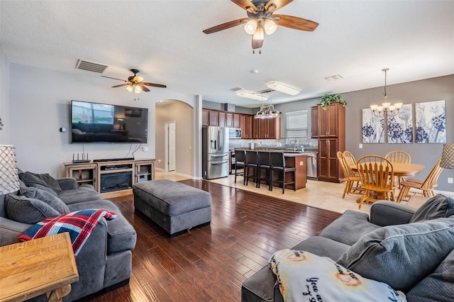 1524 Rhodeswell Ln, Dover, FL 33527 - living room featuring ceiling fan, light wood-style flooring, arched walkways, and a chandelier