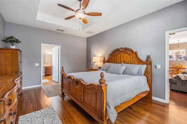 1524 Rhodeswell Ln, Dover, FL 33527 - bedroom featuring hardwood / wood-style floors, a raised ceiling, baseboards, and ensuite bathroom