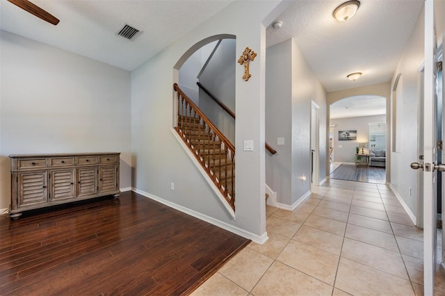1524 Rhodeswell Ln, Dover, FL 33527 - foyer with arched walkways, wood finished floors, baseboards, stairs, and a textured ceiling