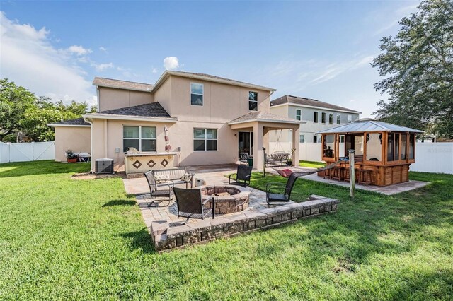 1524 Rhodeswell Ln, Dover, FL 33527 - rear view of house featuring a gazebo, a fire pit, stucco siding, a patio, and central AC