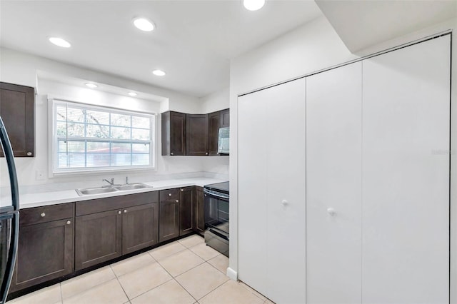 8521 N 29th St, Tampa, FL 33604 - kitchen featuring a sink, black electric range, dark brown cabinets, white microwave, and light countertops
