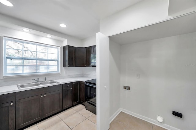 8521 N 29th St, Tampa, FL 33604 - kitchen featuring electric range, a sink, light countertops, light tile patterned floors, and dark brown cabinetry