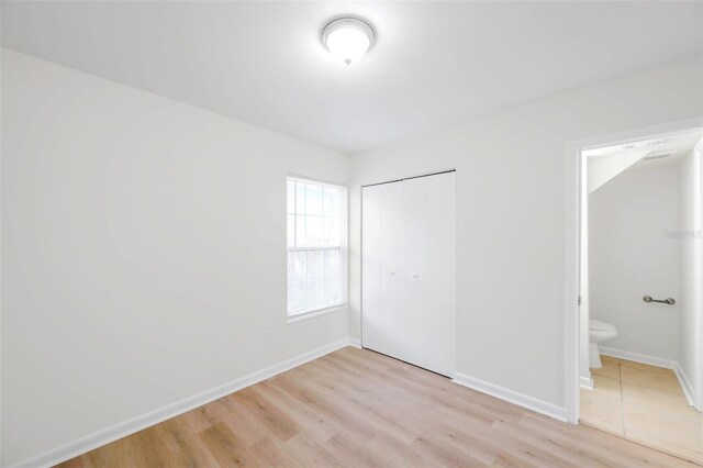 8521 N 29th St, Tampa, FL 33604 - unfurnished bedroom featuring light wood-type flooring, a closet, and baseboards