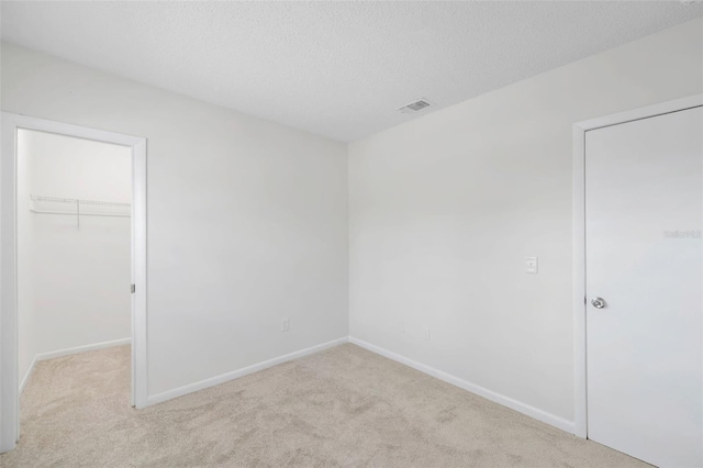 8521 N 29th St, Tampa, FL 33604 - unfurnished bedroom featuring carpet floors, a spacious closet, baseboards, a closet, and a textured ceiling