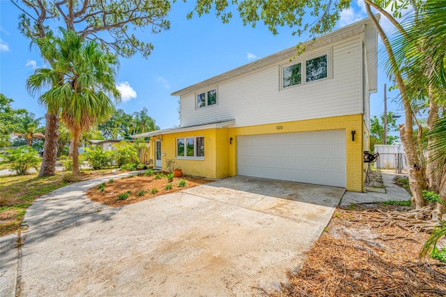 320 Tallahassee Dr NE, Saint Petersburg, FL 33702 - view of front facade featuring brick siding, an attached garage, driveway, and a gate
