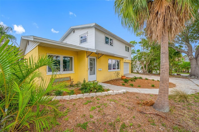 320 Tallahassee Dr NE, Saint Petersburg, FL 33702 - view of front facade with brick siding, an attached garage, and concrete driveway