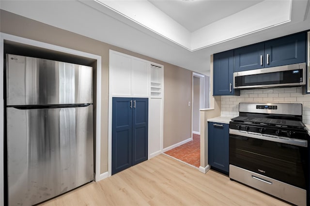 320 Tallahassee Dr NE, Saint Petersburg, FL 33702 - kitchen with stainless steel appliances, blue cabinets, light wood-style flooring, and backsplash